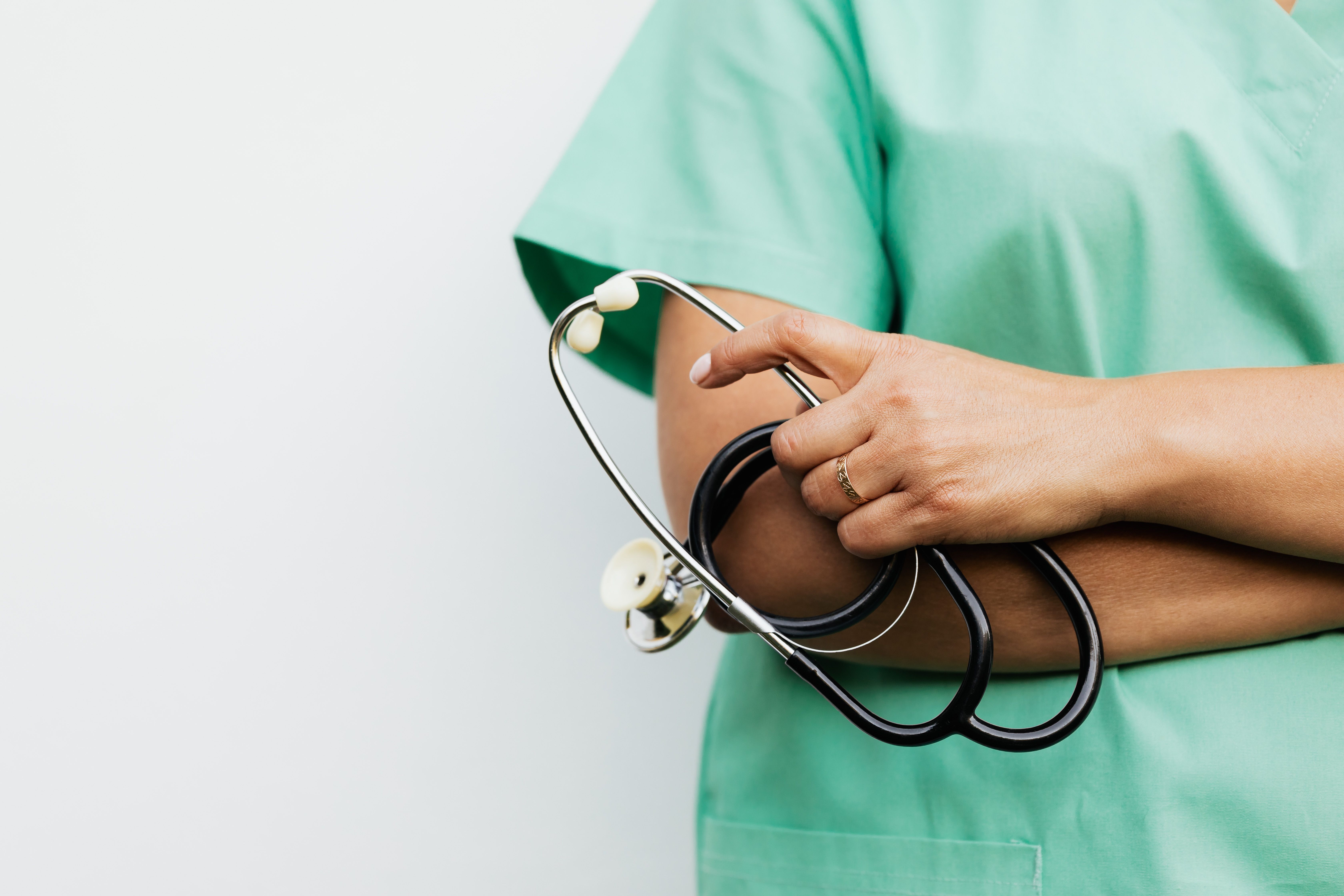 Nurse in scrubs holding a stethoscope